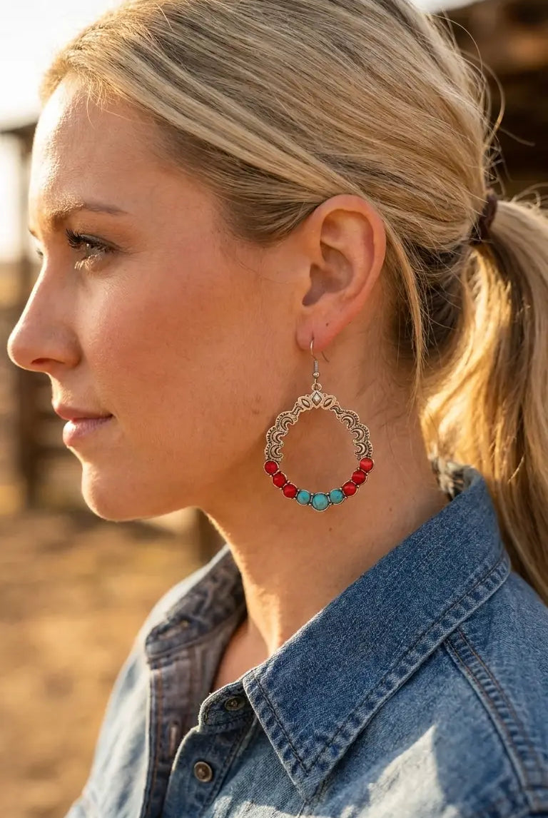 Close-up wearing the Cowhide & Conchos turquoise and coral hoop earrings — coral and turquoise western detail.