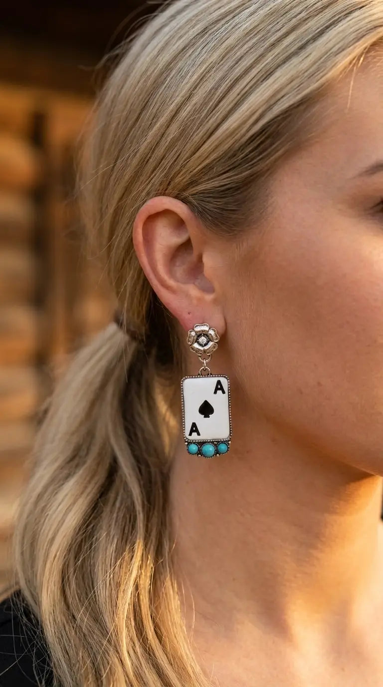 Close-up wearing the Cowhide & Conchos Ace of Spades earrings — western card detail up close.