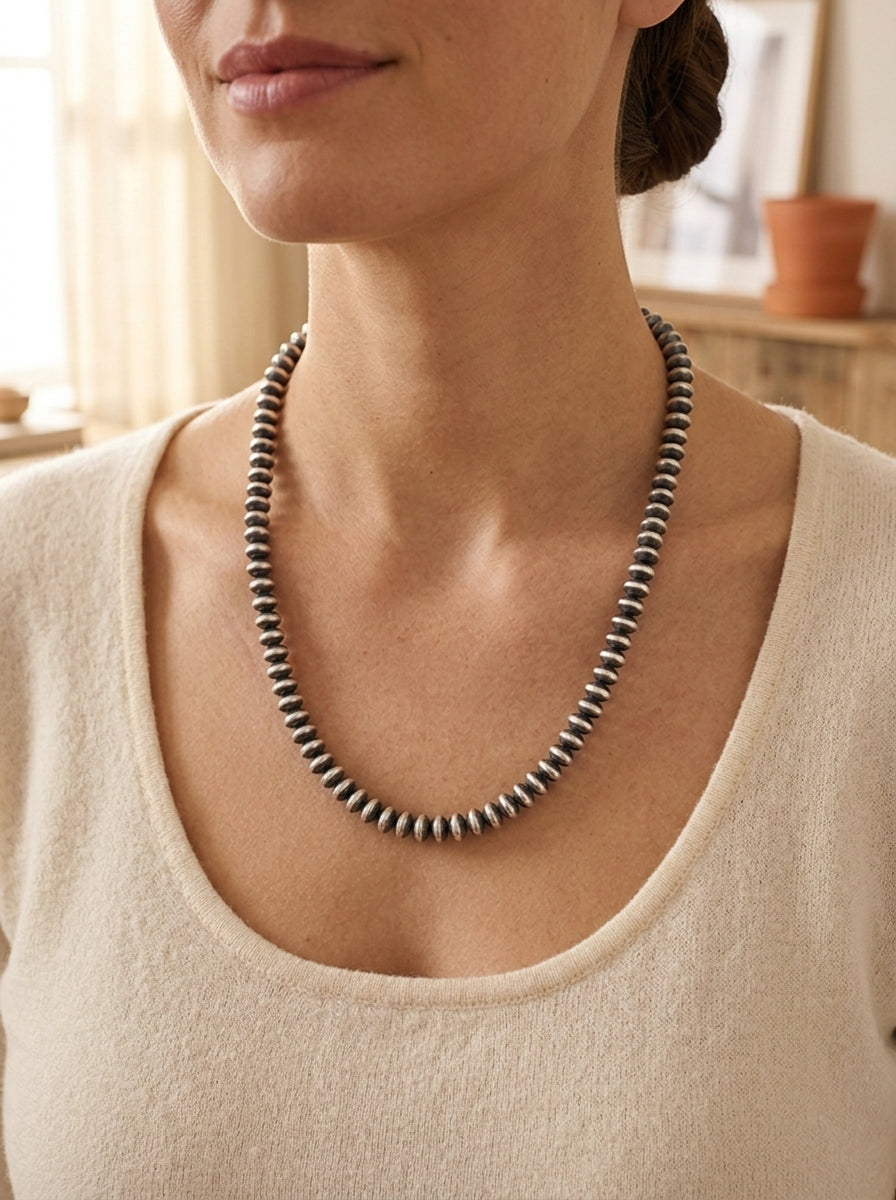 Close-up of the Cowhide & Conchos Bryannen Halwood Navajo Saucer Pearl Necklace — flat saucer-disc sterling beads, authentic Navajo craftsmanship.