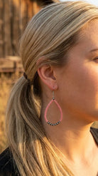 Close-up wearing the Cowhide & Conchos pink stone teardrop earrings — playful western charm.