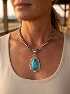 Close-up of the Cowhide & Conchos Thomas Francisco Kingman Turquoise Pendant on a sterling pearl necklace — vibrant blue Kingman turquoise and handcrafted silver, heirloom Western detail.