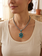Close-up of the Cowhide & Conchos Kathleen Livingston Sonoran Turquoise Pendant on a sterling pearl necklace — vivid Sonoran turquoise in tall narrow silverwork, heirloom detail.
