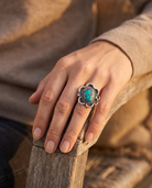 Close-up of the Cowhide & Conchos turquoise cabochon sterling silver flower-base ring — up close.