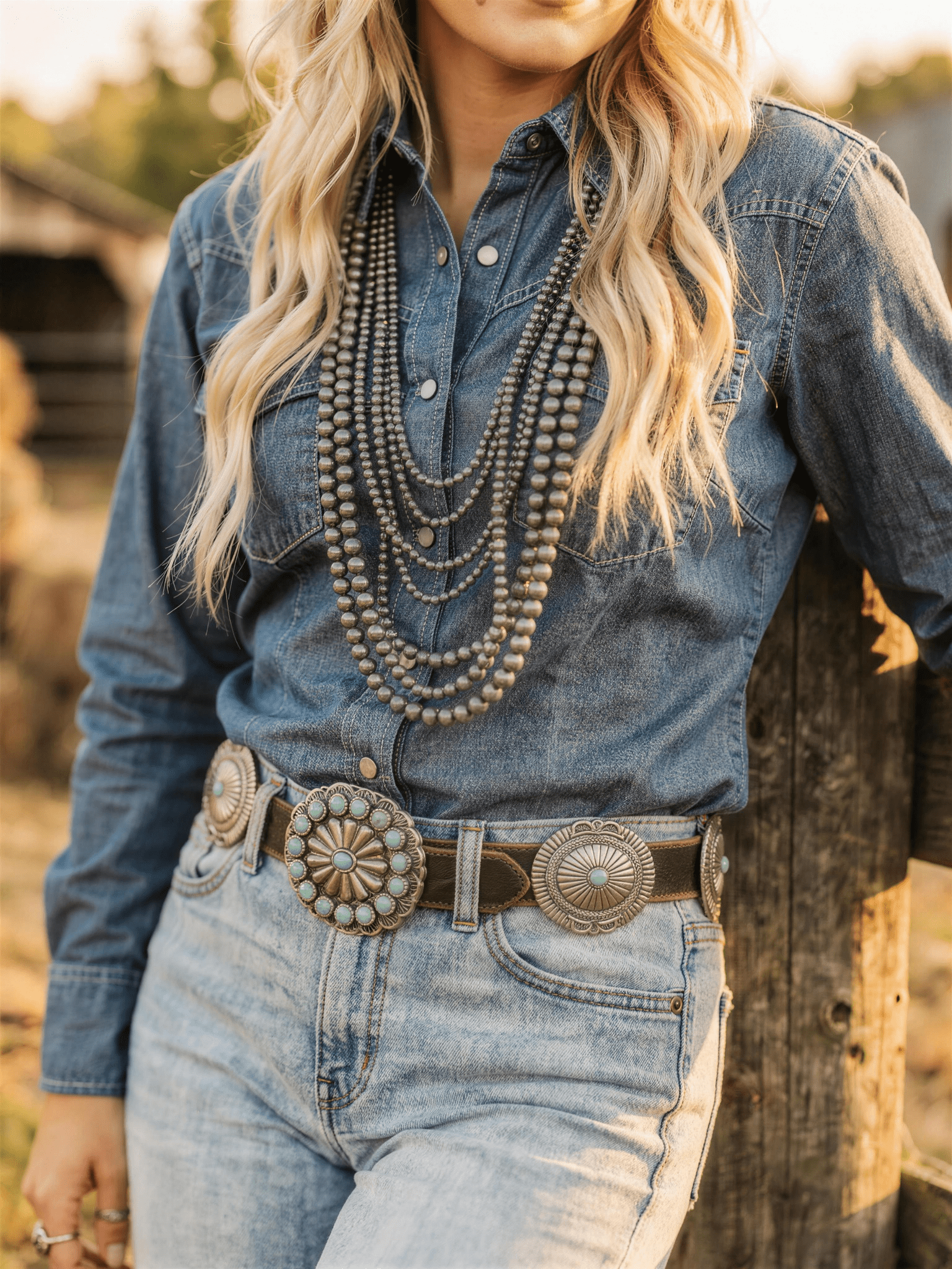 Distressed leather concho belt styled with an eight-row burnished silver pearl necklace set